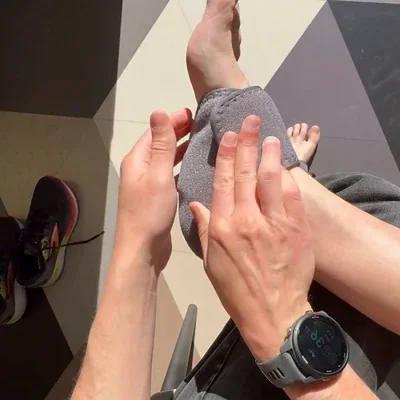 Een handpalm strijkt de al aangetrokken Stepeva-manchet glad over de wreef, met de tenen zichtbaar en een horloge om de pols